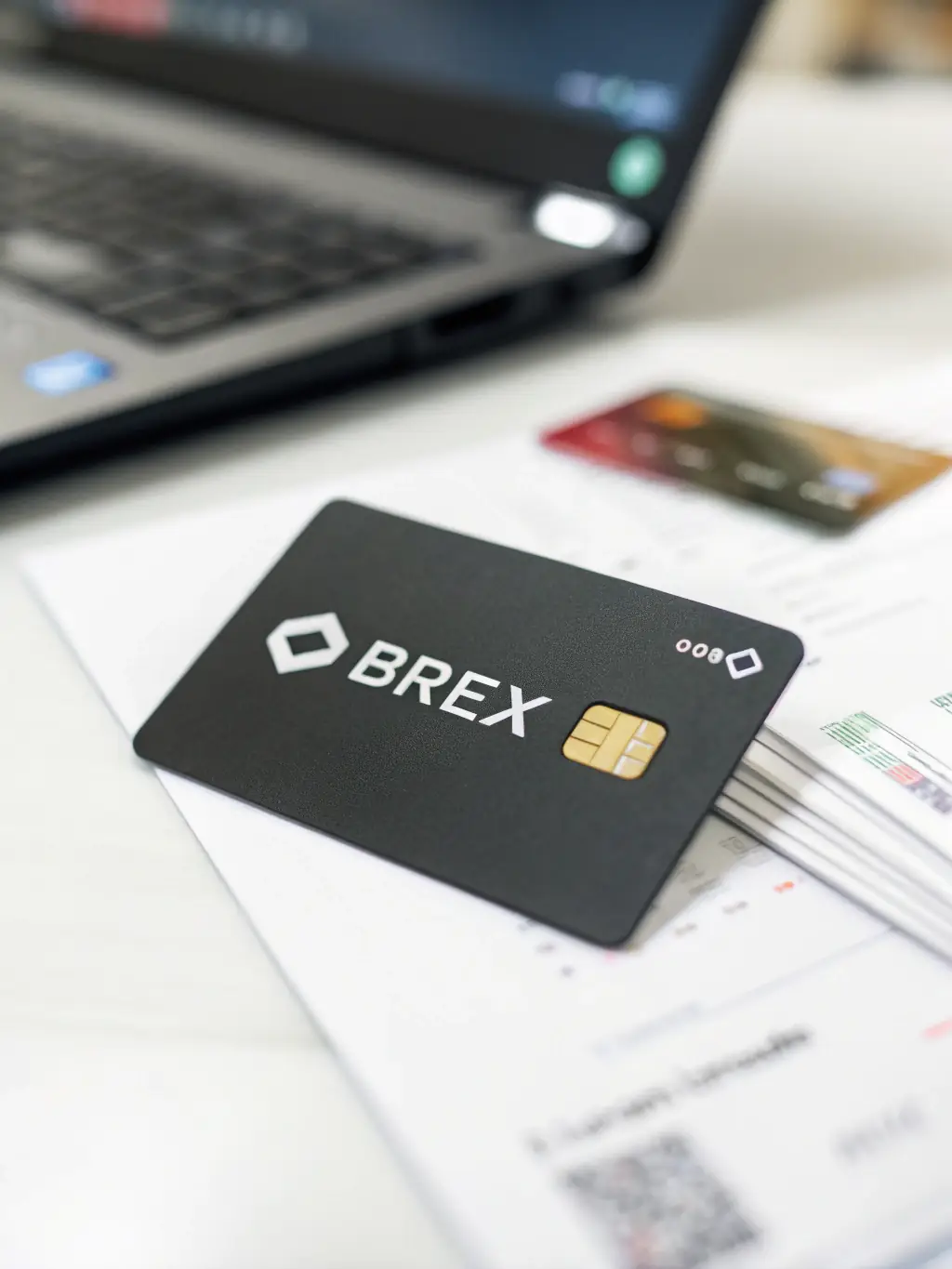 A professional-looking Brex corporate card with a small business logo subtly displayed in the background, emphasizing the card's design and functionality.